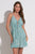 Woman wearing a teal Elan Tiered Mini Dress against a white background