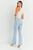 Woman wearing light blue jeans and a white top on a white background