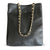 Black perforated handbag with a gold chain strap on a white background